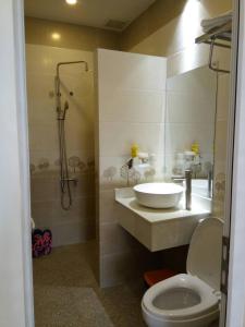 a bathroom with a sink and a shower and a toilet at Khách sạn mini Khang Thịnh in Da Lat