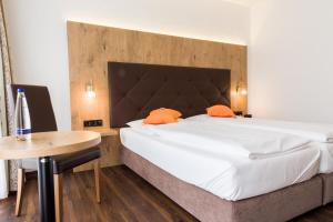 a bedroom with a large bed and a table at Stadthotel Berggeist in Penzberg