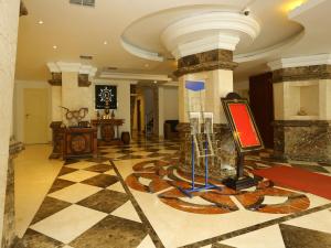 a lobby with a checkered floor with a painting on it at Emarald Suites, Cochin in Cochin