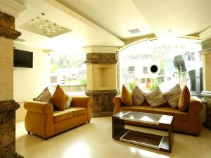 a living room with two couches and a coffee table at Emarald Suites, Cochin in Cochin