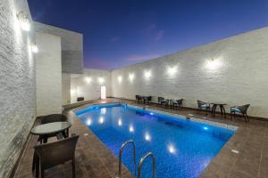 a pool in a hotel with chairs and a table at Braira Al Wezarat in Riyadh