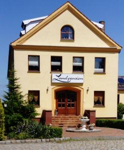 a house with a sign on the front of it at Landpension Wendfeld in Sanitz