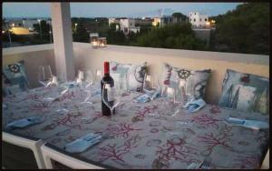 a table with a bottle of wine and glasses on it at Casa Nettuno Favignana in Favignana