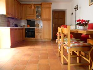a kitchen with wooden cabinets and a table and chairs at Maso Pianezza House in Calceranica al Lago