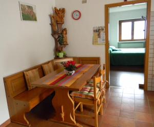 a dining room with a wooden table and chairs at Maso Pianezza House in Calceranica al Lago