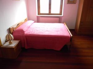 a bedroom with a bed with a red blanket at Maso Pianezza House in Calceranica al Lago