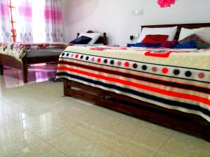 een slaapkamer met 2 bedden met rood wit en blauw bij Ella Sunrise in Ella