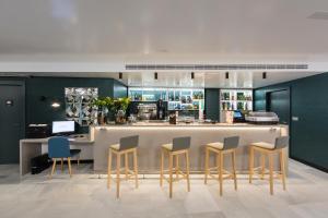 a restaurant with a bar with chairs and a counter at Catalonia Granada in Granada