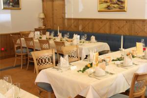 un comedor con mesas y sillas con mantel blanco en Gasthof Bad Hochmoos, en Lofer