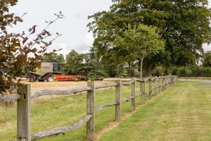 a wooden fence with a tractor in a field at Oakley Hall Hotel in Basingstoke