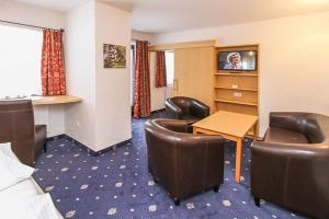 ein Hotelzimmer mit Stühlen, einem Tisch und einem Schreibtisch in der Unterkunft Gasthof Bad Hochmoos in Lofer