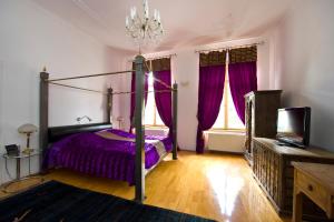 a bedroom with a bed with purple sheets and windows at Bon-Apart in Görlitz