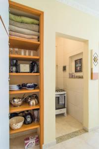 a kitchen with a shelf with dishes and a stove at Flat General in Petrópolis