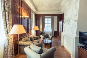 een woonkamer met een bank en stoelen en een televisie bij Hotel Schloss Neustadt-Glewe in Neustadt-Glewe