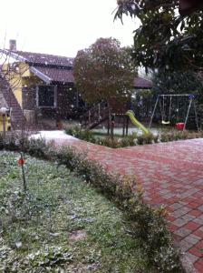 un parque infantil en un patio con un columpio en Agriturismo La Madonnina, en Castrovillari
