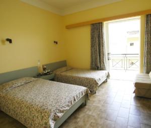 a bedroom with two beds and a large window at Ilis Hotel in Olympia