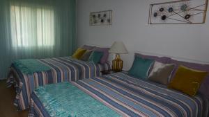 Beach Flat - Apartamento Praia Doca do Cavacas tesisinde bir odada yatak veya yataklar