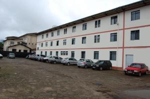 a large white building with cars parked in a parking lot at Hotel Muller in Mariana