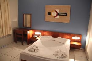 a bedroom with a white bed with a blue wall at Hotel Muller in Mariana