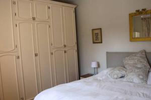 a bedroom with a white bed and a large white cabinet at Casa Lawrence in Brisino