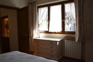 a bedroom with a bed and a window and a dresser at Casa Lawrence in Brisino