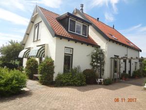 een wit huis met een rood dak bij B&B Landleven in Hellevoetsluis