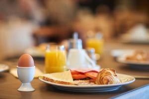 a plate of food and an egg on a table at Hotel 't Putje in Bruges +35 photos