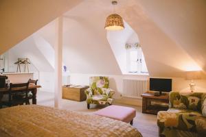 a bedroom with a bed and a desk and a tv at The Hero in Burnham Market