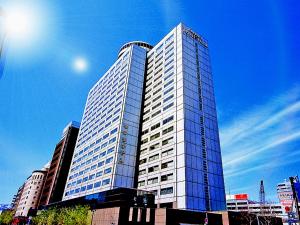 a tall glass building with a blue sky at Century Royal Hotel Sapporo in Sapporo