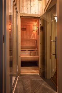 a walk in shower in a bathroom with wooden walls at Wellness Hotel Republika 24 Apartments in Pilsen
