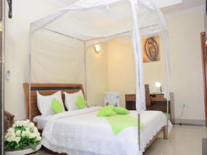 1 Schlafzimmer mit 2 Betten und einem Himmelbett in der Unterkunft Five to Five Hotel in Kigali