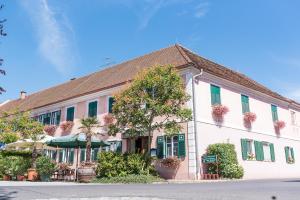 un gran edificio blanco con ventanas con contraventanas verdes en Gasthof zum Hirschen, en Burgau