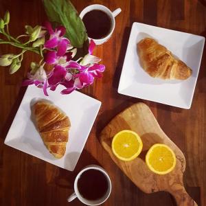 una mesa con dos platos de pan y dos tazas de café en La Grange Fleurie en Tramayes