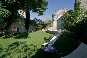 einen Rasen mit einem Stuhl im Hof eines Hauses in der Unterkunft Maison De La Bourgade in Uzès