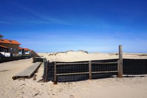 ビスカロッスにある112 RÉSIDENCE LES SABLES -004の塀と砂のベンチのある浜