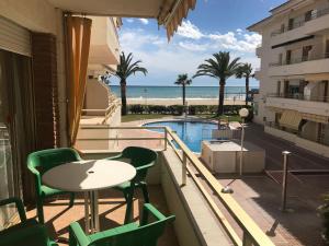 a balcony with a table and chairs and a view of the beach at COSTA DAURADA APARTAMENTS - Colibri Beach in Cambrils