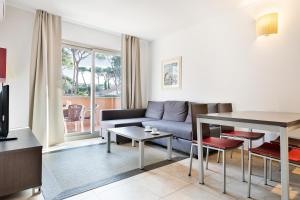 Aparthotel Bardon في كاستيلديفِيلس: غرفة معيشة مع أريكة وطاولة