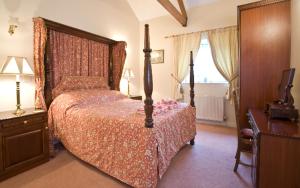 a bedroom with a bed and a dresser and a table at The Stables in South Barrow