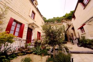 a building with red windows and a courtyard with plants at Beaulieu La Source in Saumur