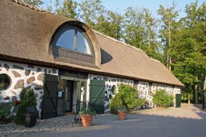 un bâtiment avec un toit de chaume et une fenêtre dans l'établissement Araslöv Golf & Resort, à Kristianstad