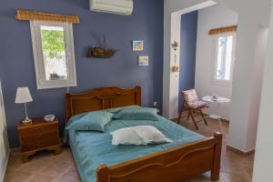 a bedroom with a bed with a blue wall at Villa Euphoria in Aegina, A' Marathonas bay in Aegina Town
