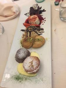 a white plate with different types of donuts on it at Albergo Diffuso Culturart House in Agrigento