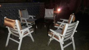 eine Gruppe weißer Stühle und ein Tisch in der Unterkunft Octobar City Villa in Kairo