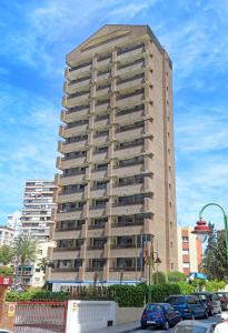een hoog gebouw met auto's geparkeerd voor het bij Aparthotel BCL Levante Beach in Benidorm