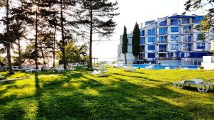 a park with chairs and a building in the background at Blue Bay Sea View in Pomorie