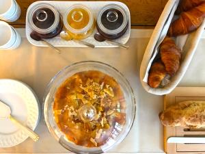 a table topped with a bowl of food and croissants at Le Clos Saluces in Avignon