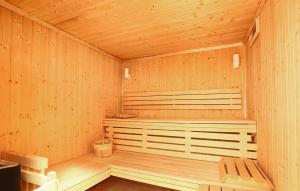 an empty wooden sauna with a bench in it at Résidence Odalys Le Village in Notre-Dame-de-Bellecombe