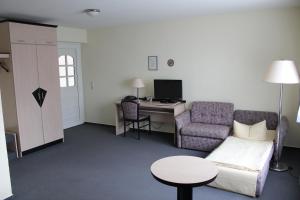 ein Wohnzimmer mit einem Sofa und einem Schreibtisch in der Unterkunft Landhaus Mienenbüttel in Neu Wulmstorf