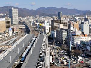 
a train is going down the tracks in a city at Hotel Granvia Okayama in Okayama
