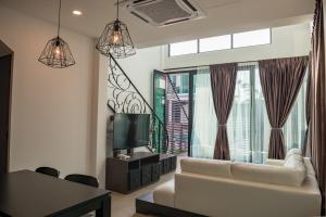 a living room with a white couch and a large window at Hermitage Boutique House in Taiping